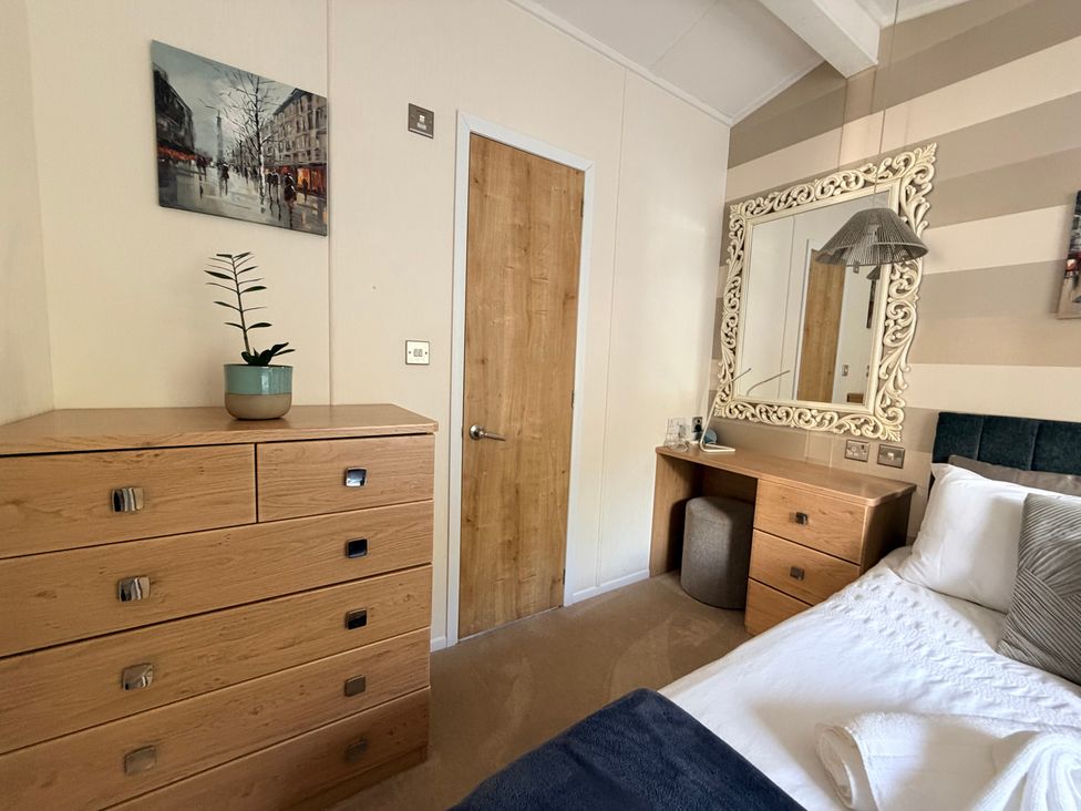 A bedroom with a bed and a mirror at Boutique Lodge in Cheriton Bishop