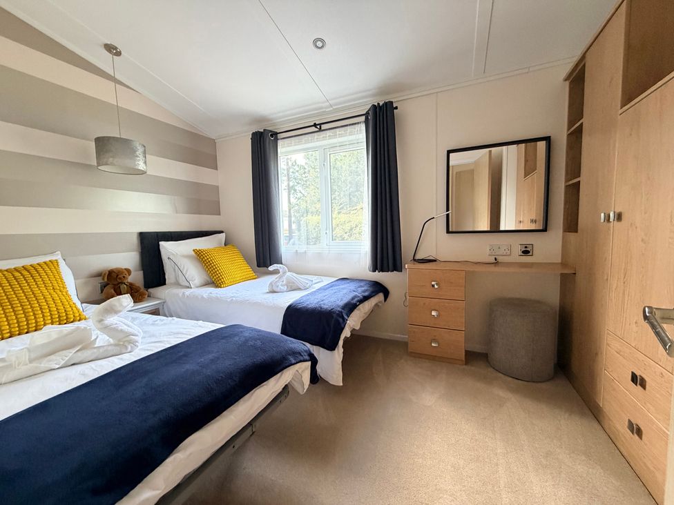 A bedroom with two beds and a desk at Boutique Lodge in Cheriton Bishop