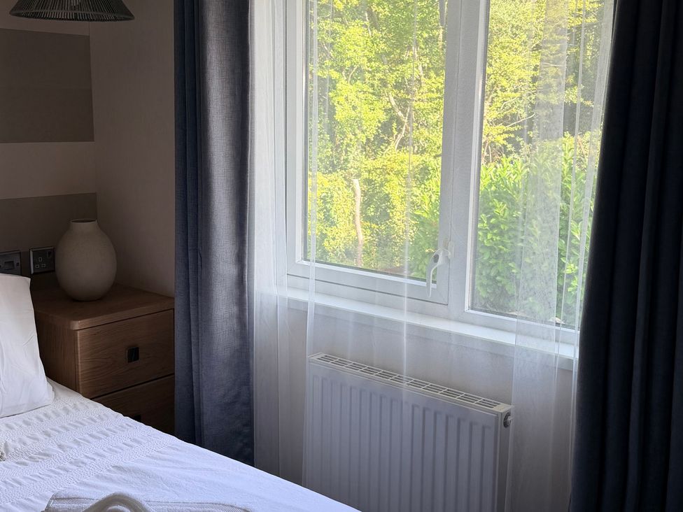 A bedroom with a bed and window at Boutique Lodge in Cheriton Bishop