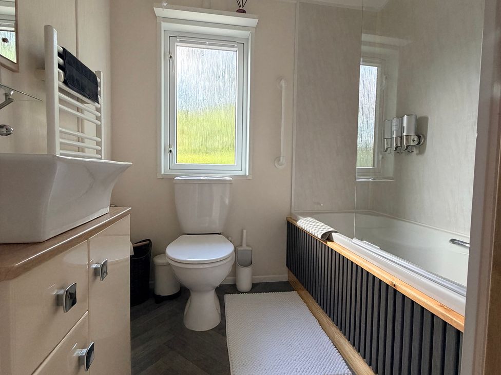 A bathroom with a sink, toilet, and bathtub at Boutique Lodge in Cheriton Bishop
