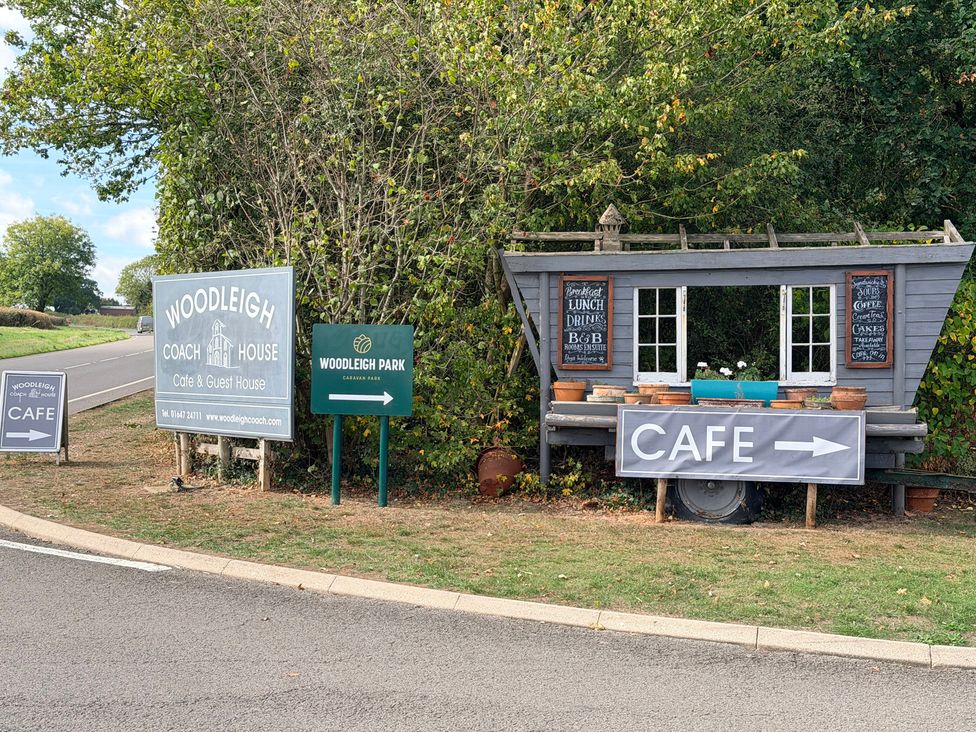 A cafe sign and guest house sign at Woodleigh Coach House in Cheriton Bishop