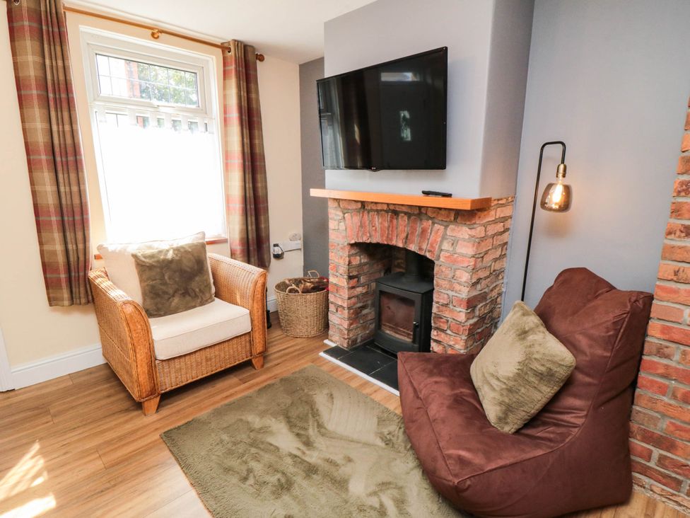 A living room with an armchair and fireplace at 45 St. Hildas Street in Sherburn
