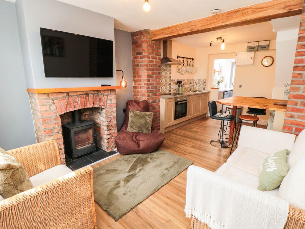 A living room with a fireplace and kitchen area at 45 St. Hildas Street Sherburn