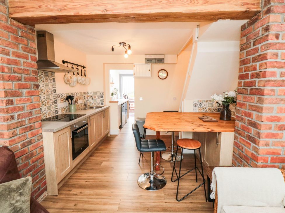 A kitchen with a dining table and bar stools at 45 St. Hildas Street in Sherburn
