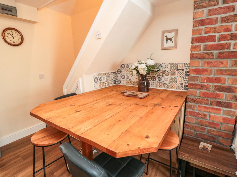 A dining room with a wooden table and stools at 45 St. Hildas Street in Sherburn