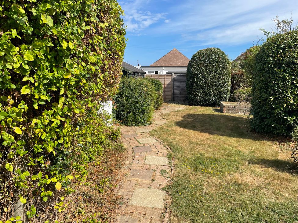 A pathway surrounded by hedges in the garden at Summer Cottage in Rustington