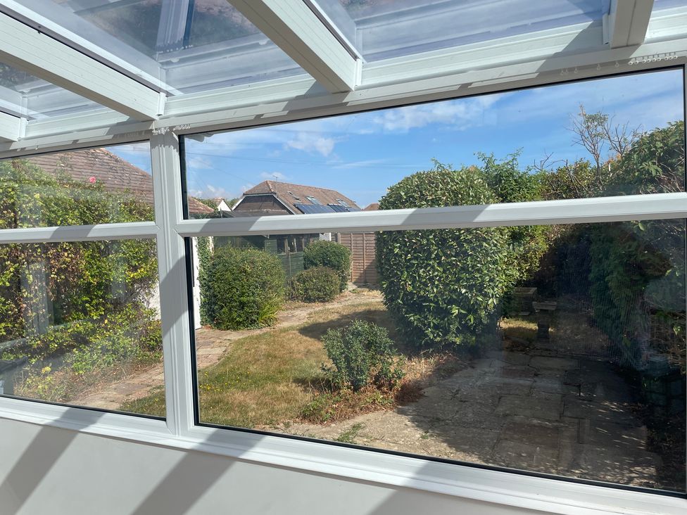 A conservatory with garden view at Summer Cottage in Rustington