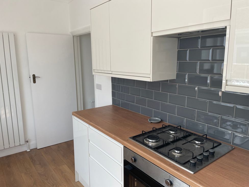 A kitchen with a stove and cabinets at Summer Cottage in Rustington
