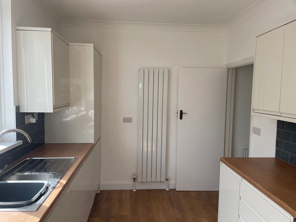 A kitchen with a sink and cabinets at Summer Cottage in Rustington