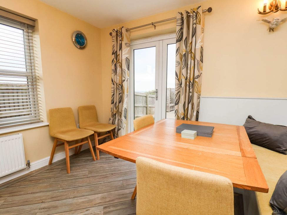 A dining room with a table and chairs at 64 Derwent Road in Whitby