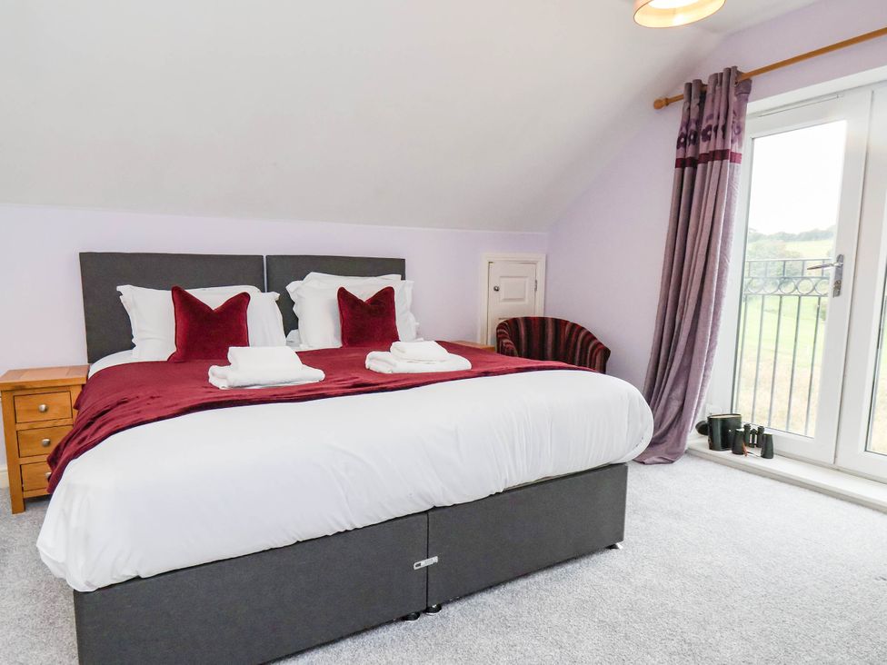 A bedroom with a bed and a nightstand at 64 Derwent Road in Whitby