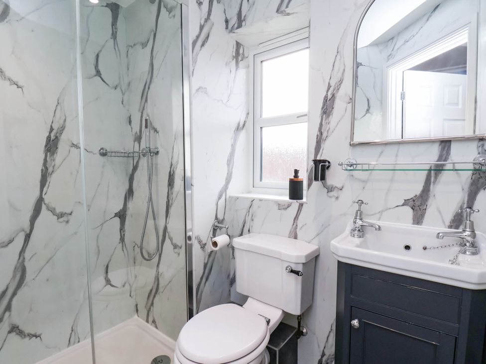 A bathroom with a shower, toilet, and sink at 64 Derwent Road Whitby