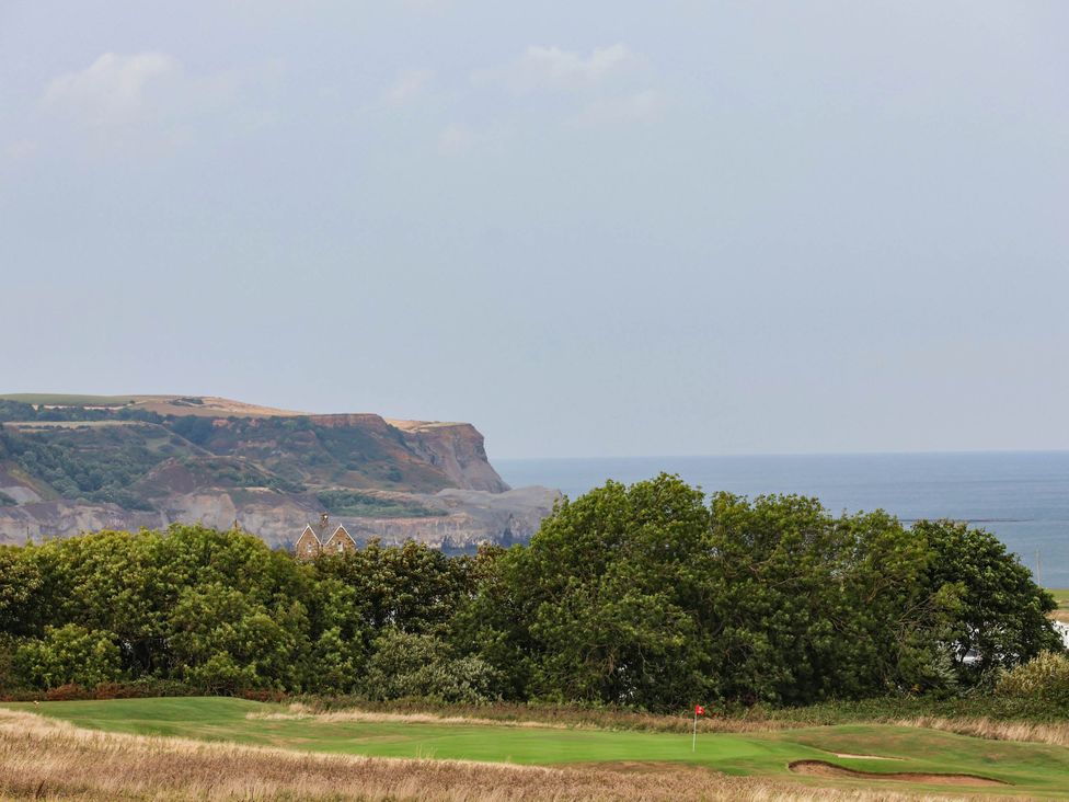 A view of cliffs and the ocean with a golf course in the foreground at 64 Derwent Road Whitby