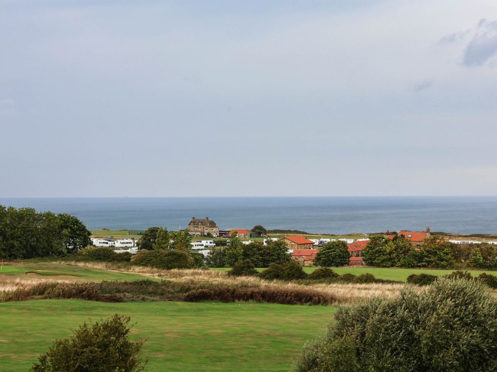 A view of the ocean, houses, and trees at 64 Derwent Road in Whitby