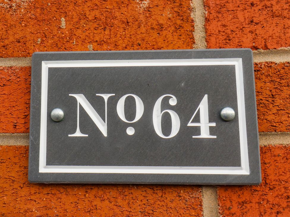 A number plaque on a brick wall at 64 Derwent Road Whitby
