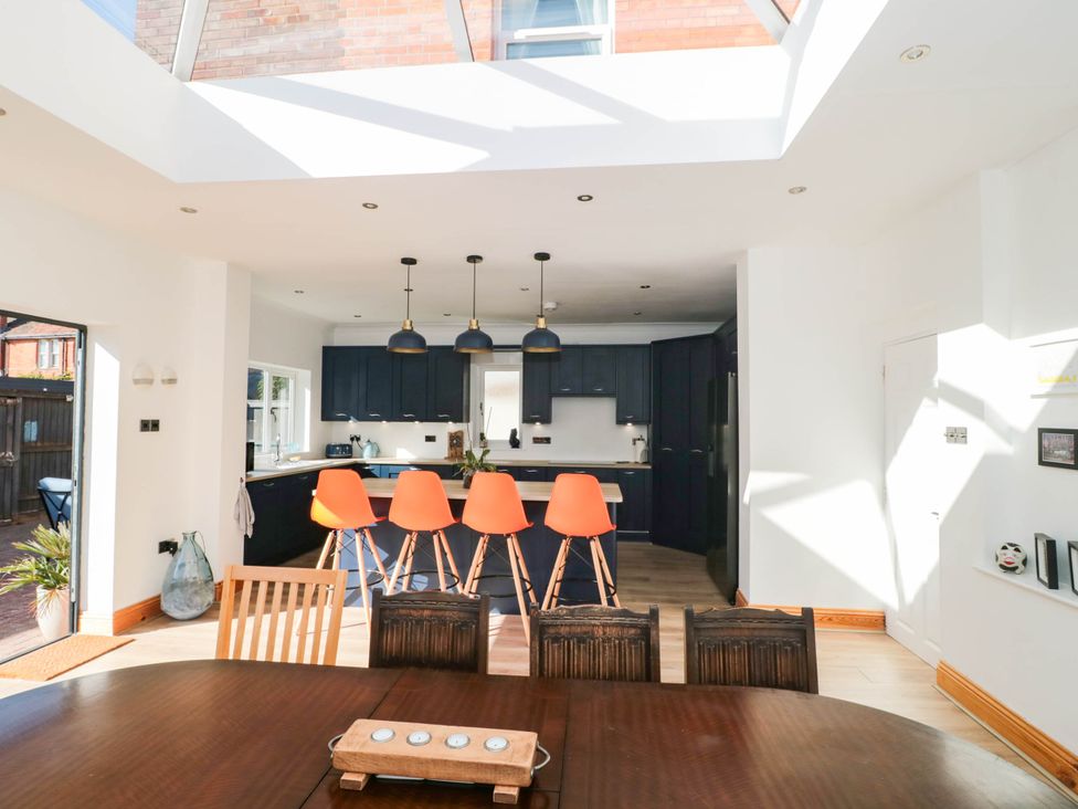 A kitchen with a dining table and bar stools at Ashbourne House
