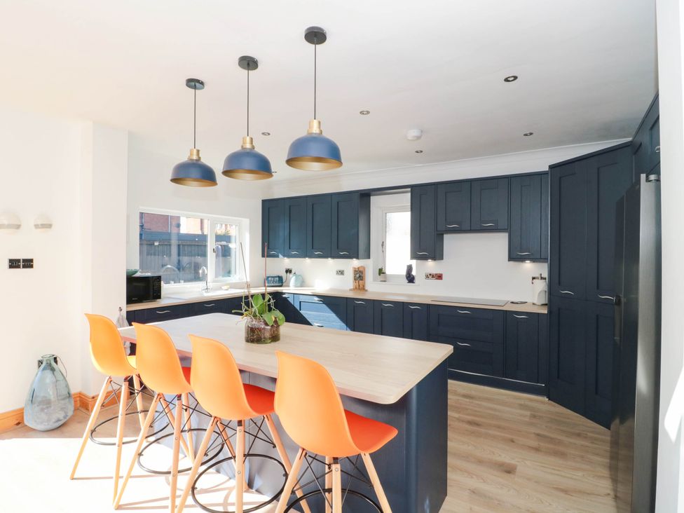A kitchen with blue cabinets and a wooden counter at Ashbourne House 
