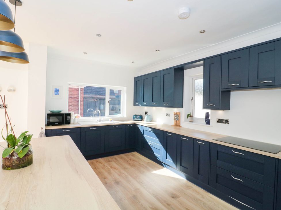 A kitchen with blue cabinets and a window at Ashbourne House