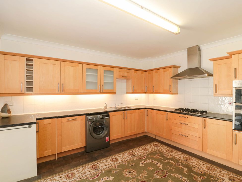 A kitchen with wooden cabinets and appliances at Ashbourne House 