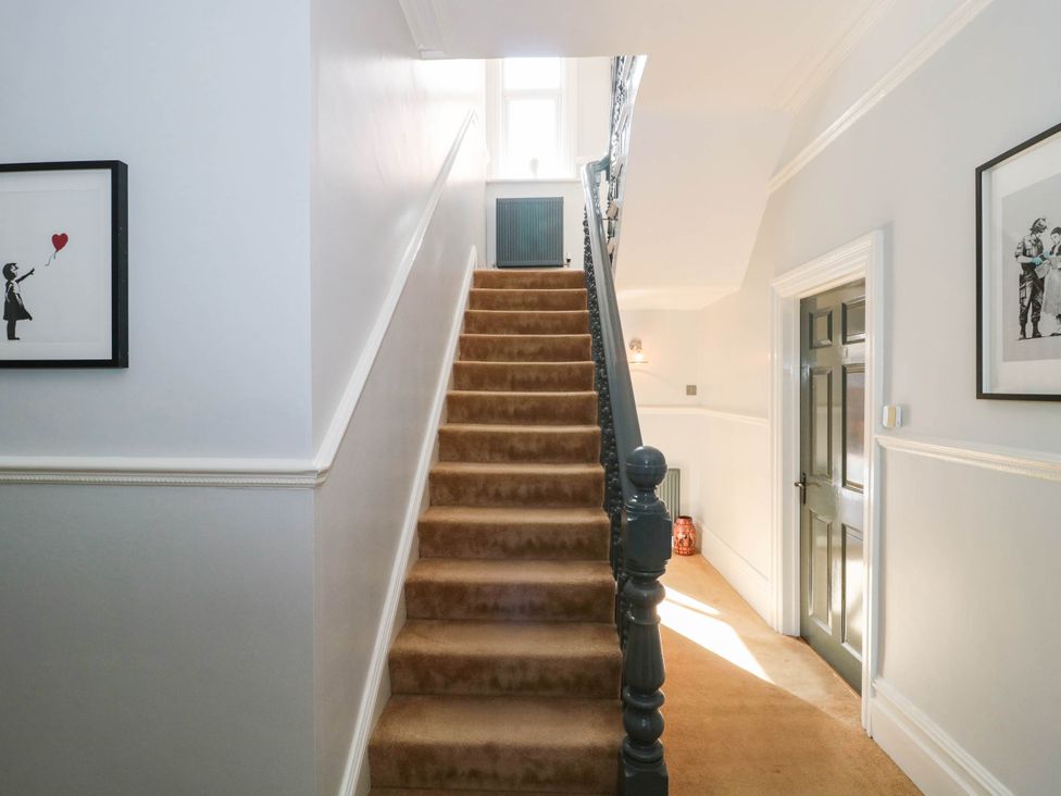 A staircase with artwork on the wall at Ashbourne House in 