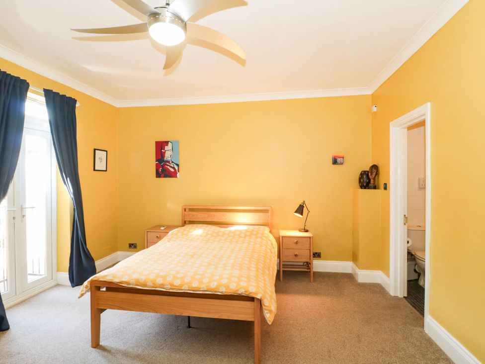 A bedroom with a bed and nightstand at Ashbourne House 