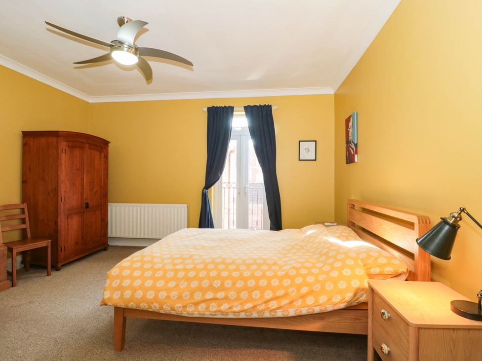 A bedroom with a bed and wardrobe at Ashbourne House