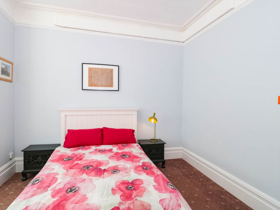 A bedroom with a bed and wall art at Ashbourne House