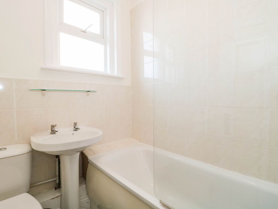 A bathroom with a bathtub, sink, and toilet at Ashbourne House 
