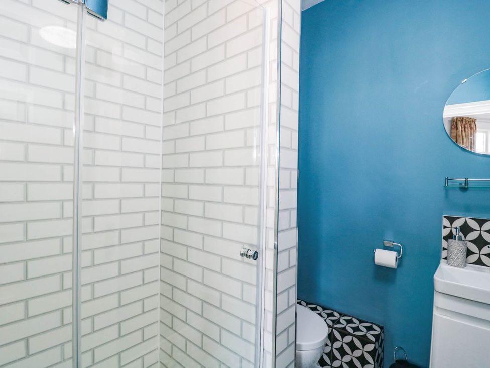 A bathroom with a shower, toilet, and sink at Ashbourne House 