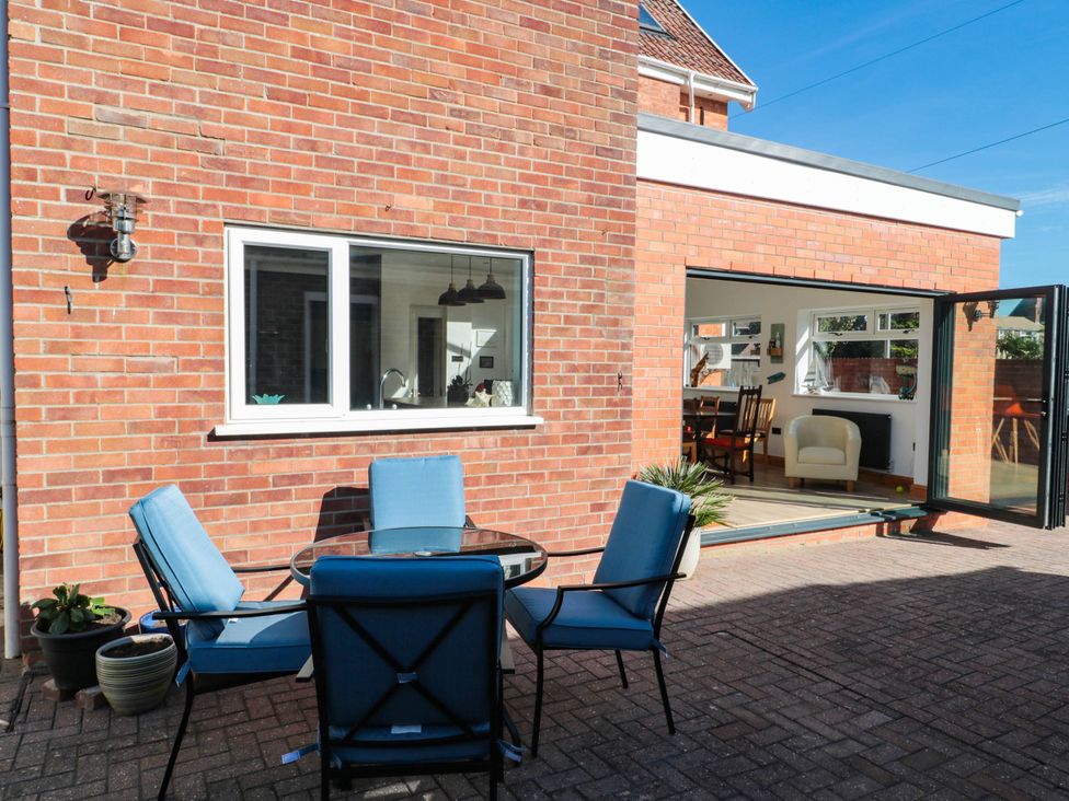 A patio area with a table and chairs at Ashbourne House 