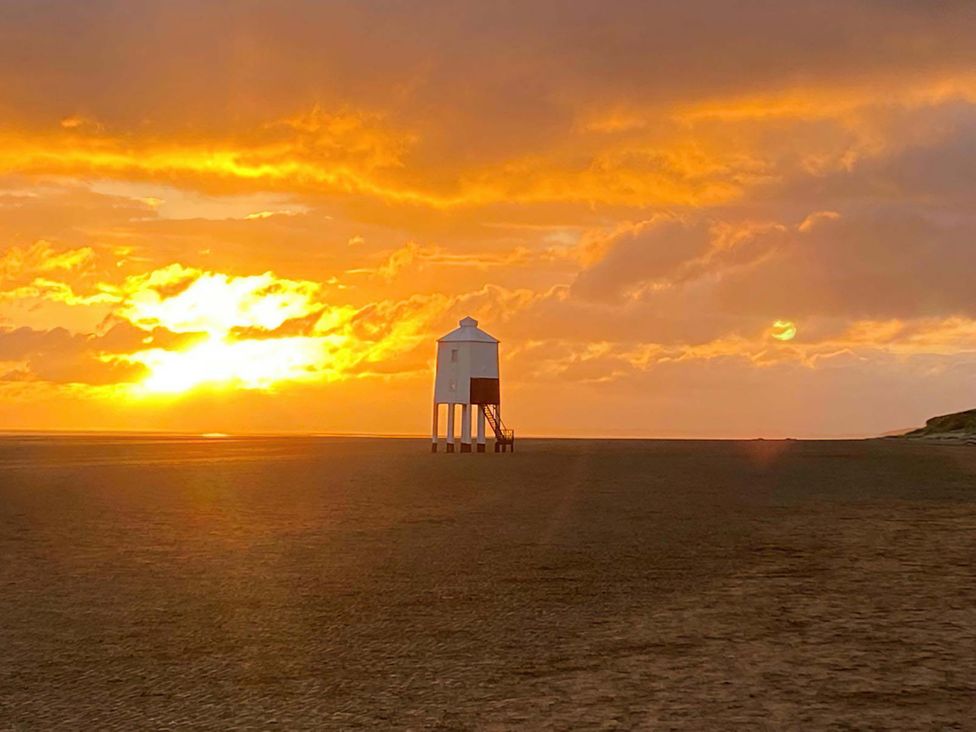 A lighthouse on a beach during sunset at Ashbourne House Burnham-On-Sea