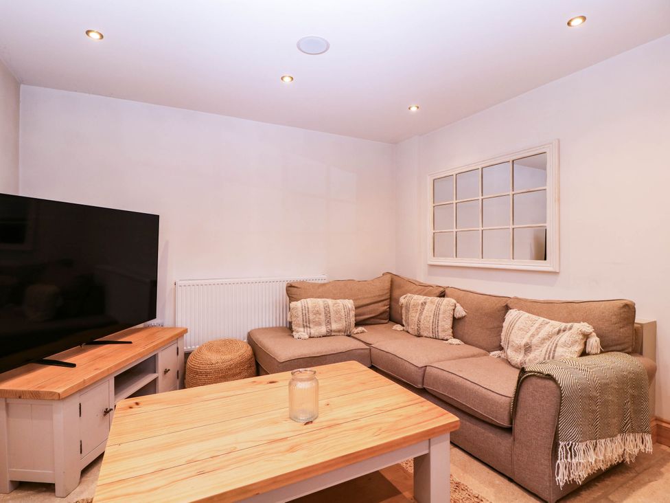 A living room with a sofa and television at The burrow at Aveling Cottage in Lydney