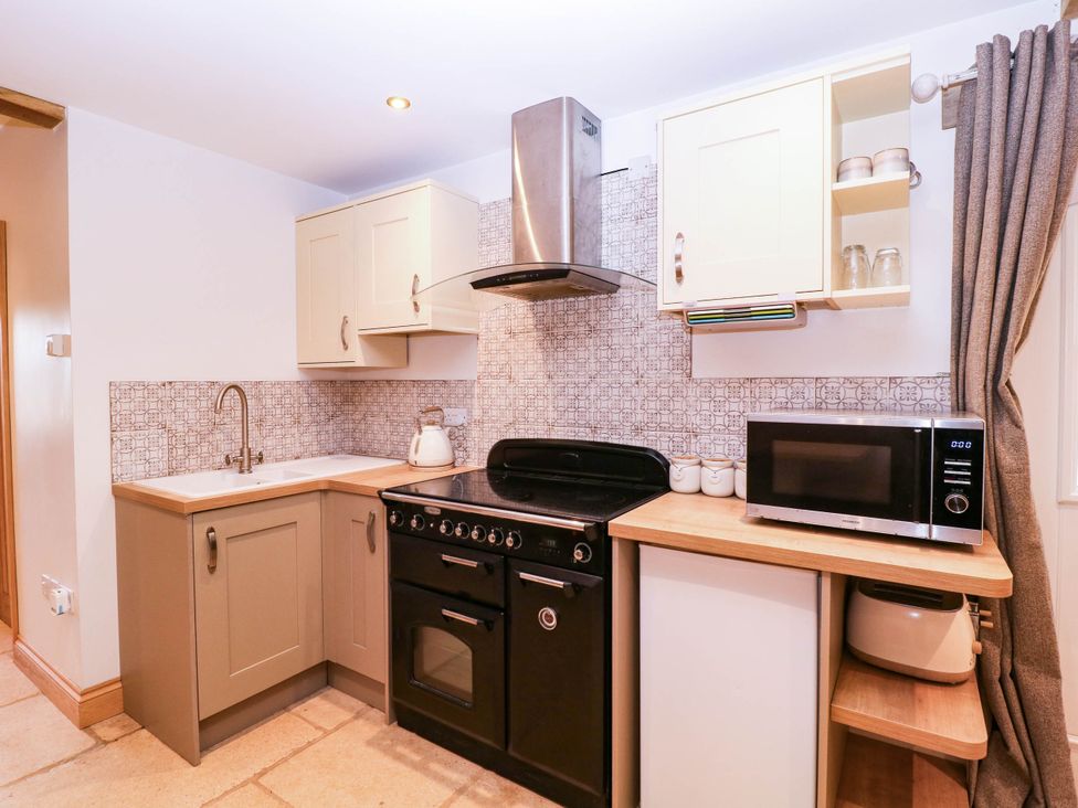 A kitchen with oven and microwave at The burrow at Aveling Cottage in Lydney