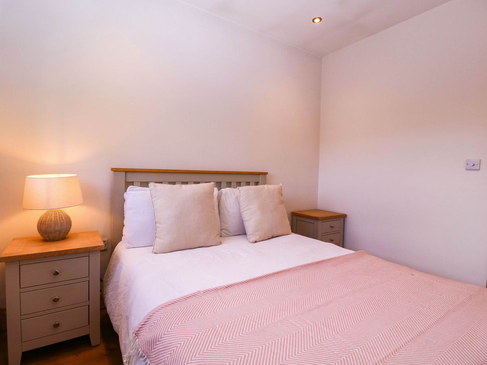 A bedroom with a bed and bedside tables at The burrow at Aveling Cottage in Lydney