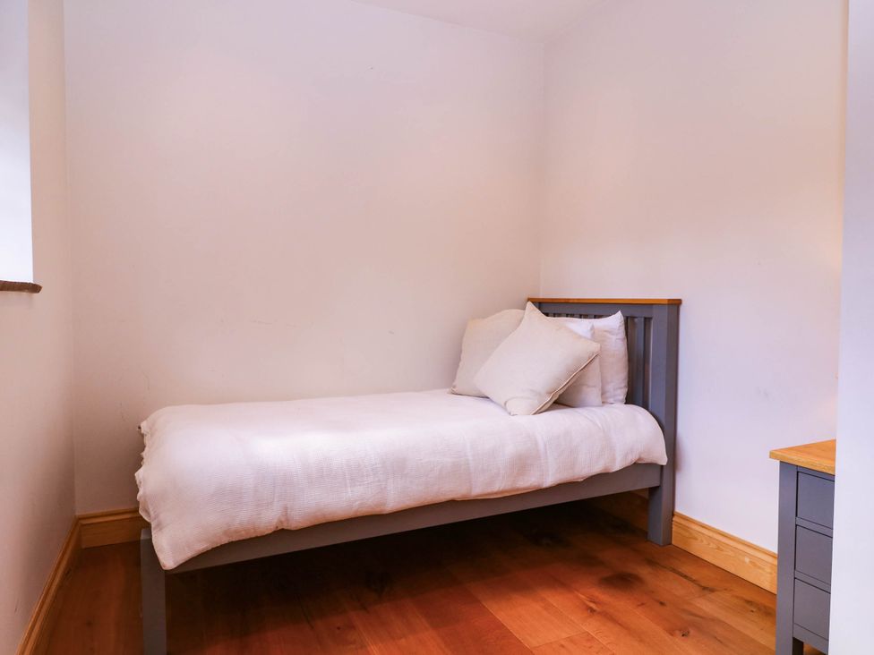 A bedroom with a single bed and a small bedside drawer at The burrow at Aveling Cottage in Lydney