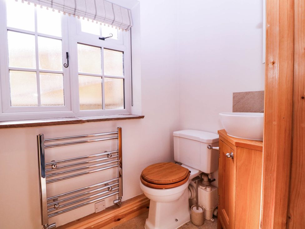 A bathroom with a toilet and washbasin at The burrow at Aveling Cottage in Lydney