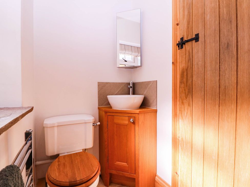 A bathroom with a toilet and sink in The burrow at Aveling Cottage Lydney