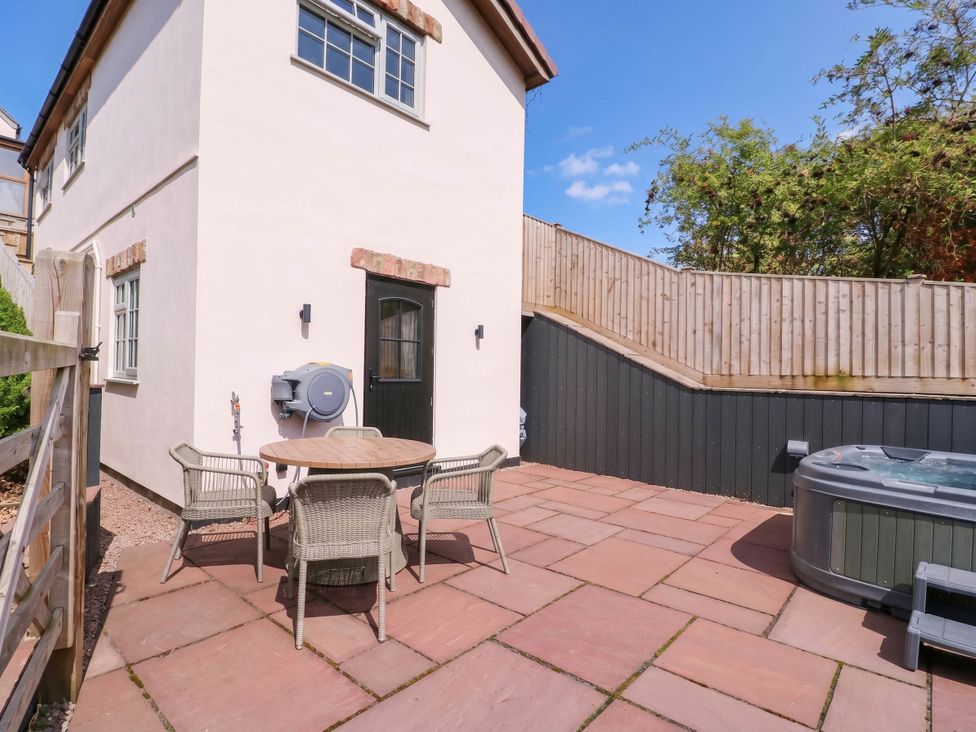 An outdoor area with a table and chairs at The Burrow at Aveling Cottage in Lydney