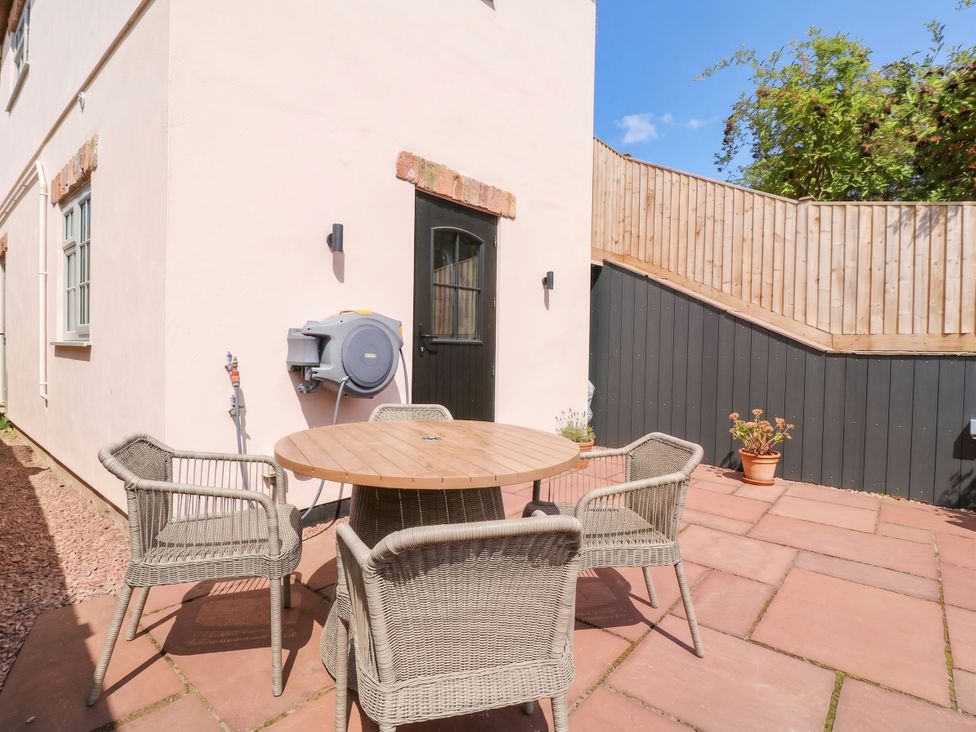 An outdoor area with a table and chairs at The burrow at Aveling Cottage Lydney