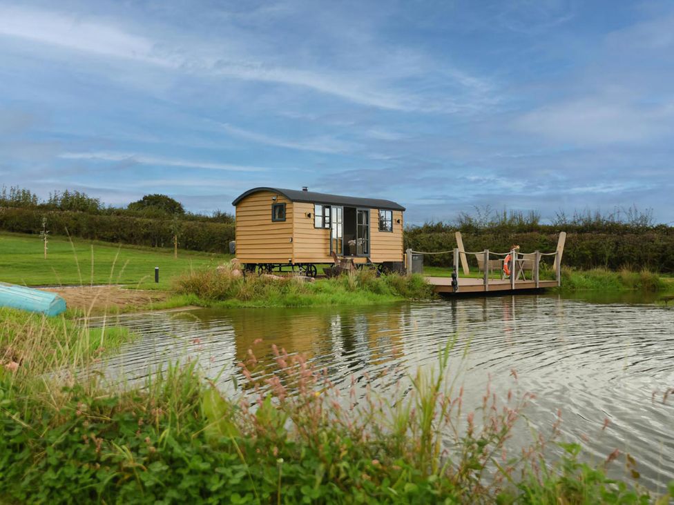 A shepherd hut near a pond at Shepherd Hut at Garden Cottage near Woolaston