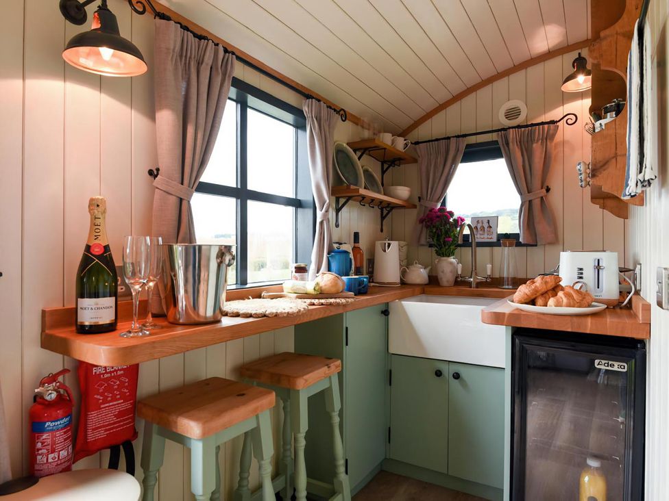 A kitchen with a sink and appliances at Shepherd Hut at Garden Cottage near Woolaston