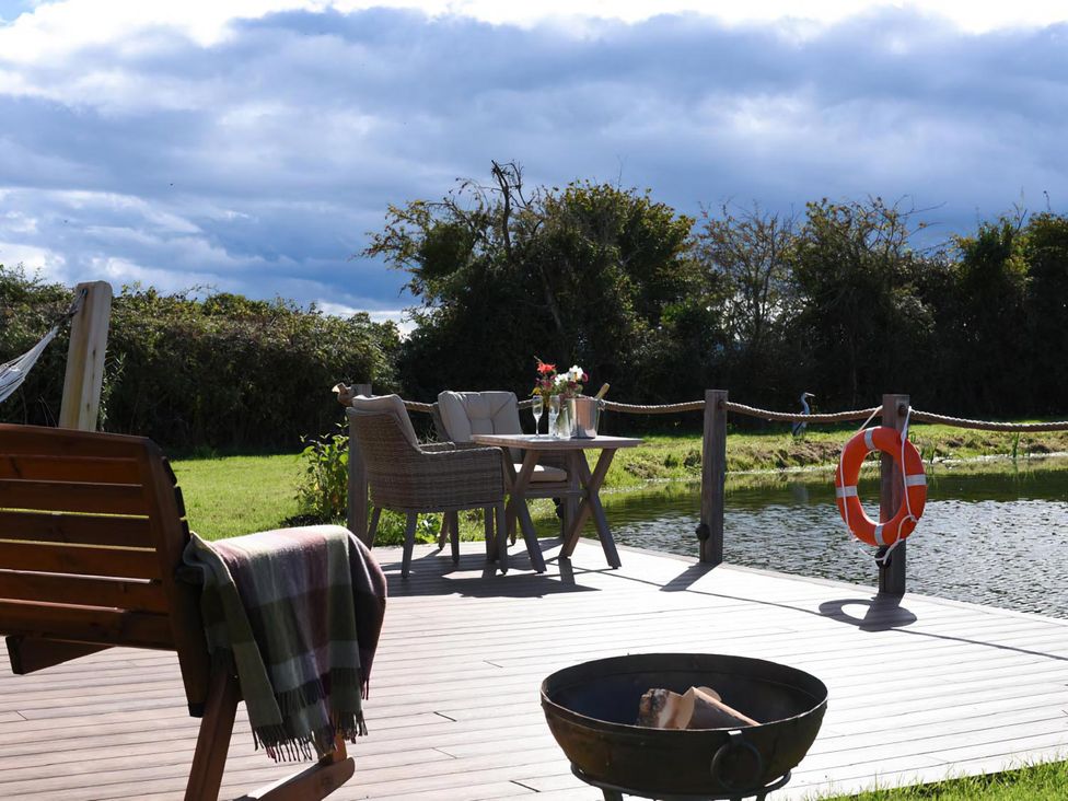 An outdoor area with seating and a fire pit at Shepherd Hut at Garden Cottage near Woolaston