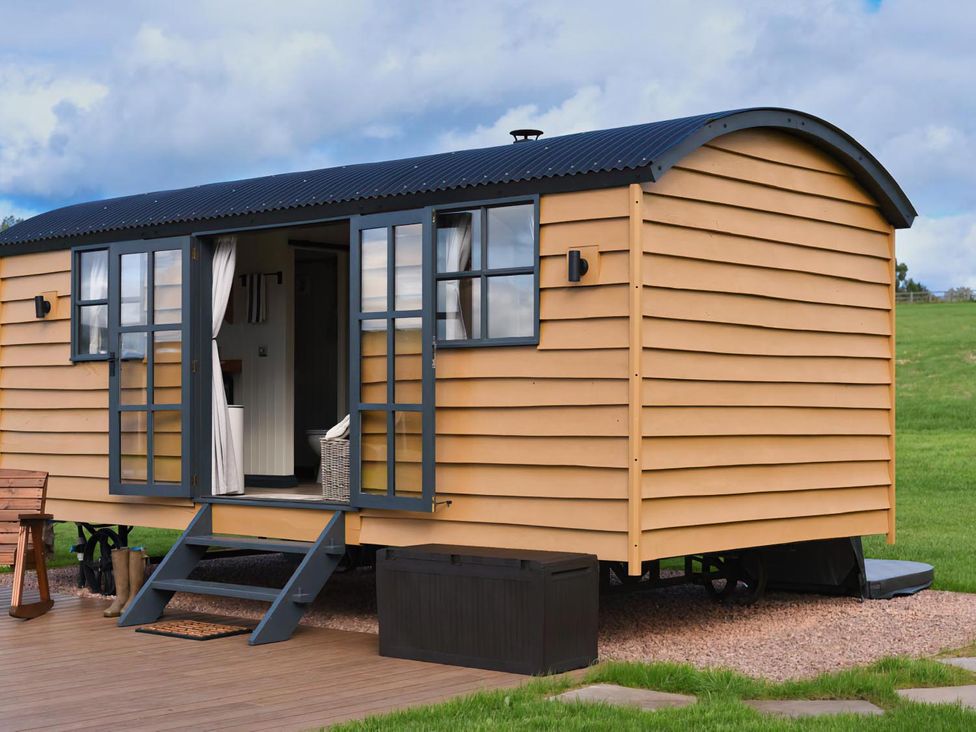 A shepherd hut with steps and windows at Shepherd Hut at Garden Cottage near Woolaston