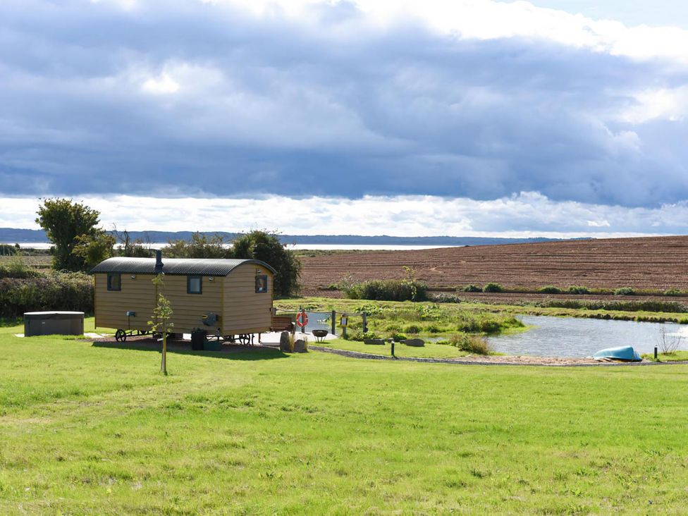 A shepherd hut by a pond at Shepherd Hut at Garden Cottage near Woolaston