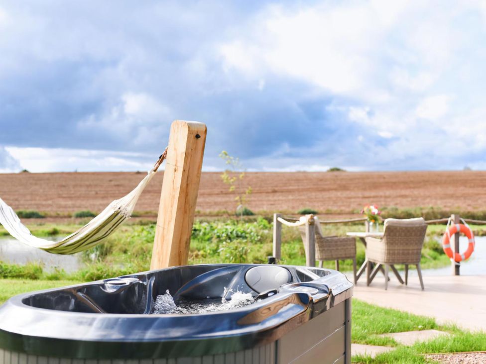 A hot tub and hammock in a garden at Shepherd Hut at Garden Cottage near Woolaston