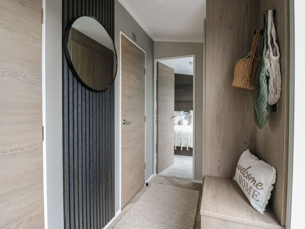 A hallway with a mirror and a bench at Lakewood Plot 7 Clacton-on-Sea