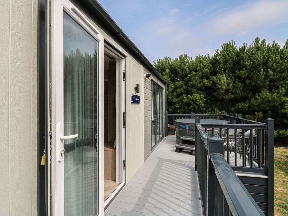 An outdoor deck with a hot tub and a door at Lakewood Plot 7 Clacton-on-Sea