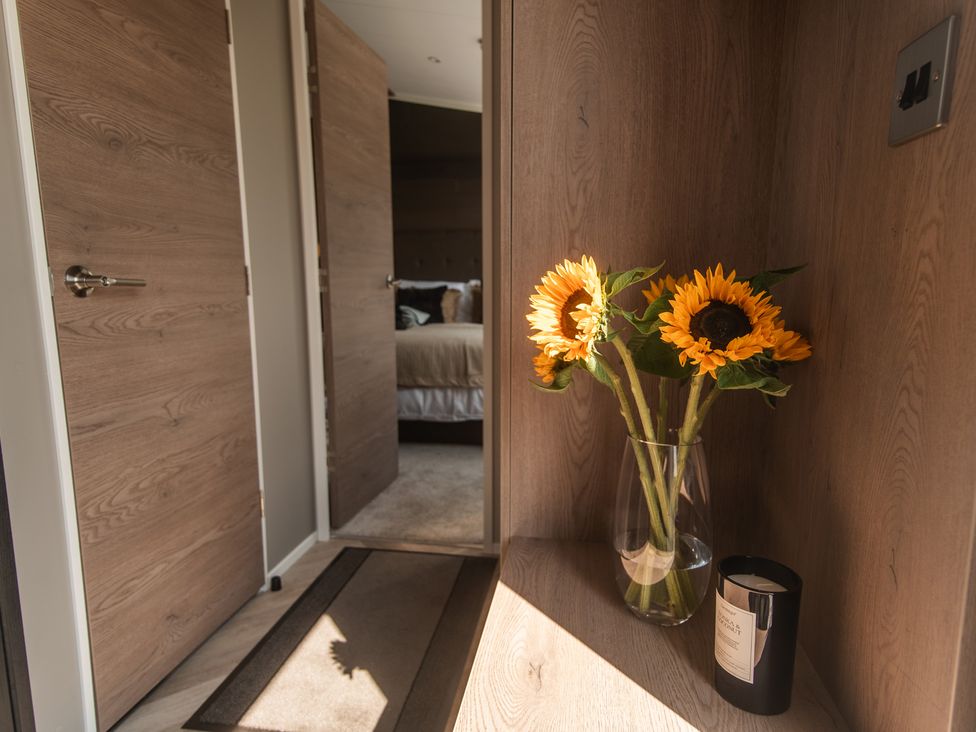 A hallway with sunflowers in a vase at Lakewood Plot 7 St. Osyth