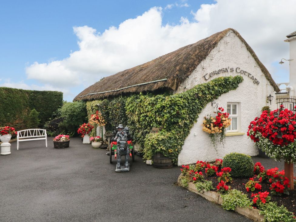 An outdoor area featuring flowers and a cottage sign at Teresa's Cottage
