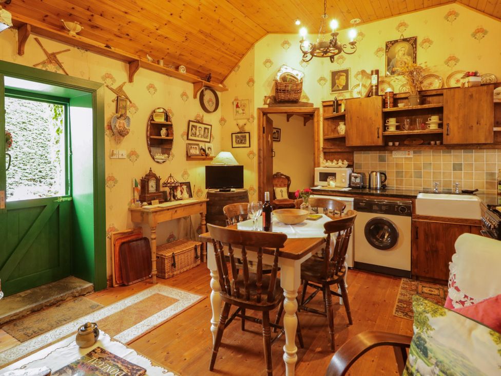 A kitchen with a wooden table and chairs at Teresa's Cottage